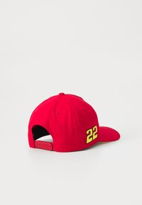 Cappello da baseball rosso con un design strutturato, presenta un '22' ricamato giallo sul retro e una chiusura regolabile a scatto.