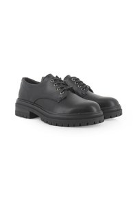 Zapatos de hombre de cuero negro con cinco ojetes para cordones, suela de goma plana, patrón de pisada circular y diseño de punta redondeada.