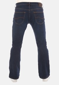 Donkerblauwe jeans met een uitlopende pijpdesign, voorzien van twee achterzakken met gebogen stiknaad en een lederen label op de tailleband.