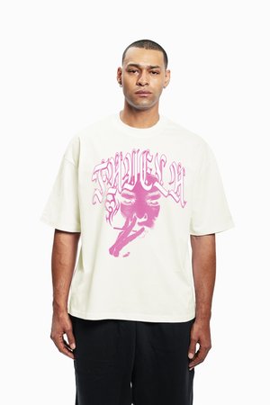 Balts pārspīlēts t-krekls ar lielu rozā grafisko attēlu, kurā attēlots sejas zīmējums ar cigareti, ar noapaļotu apkakli, īsām piedurknēm un brīvu piegriezumu.