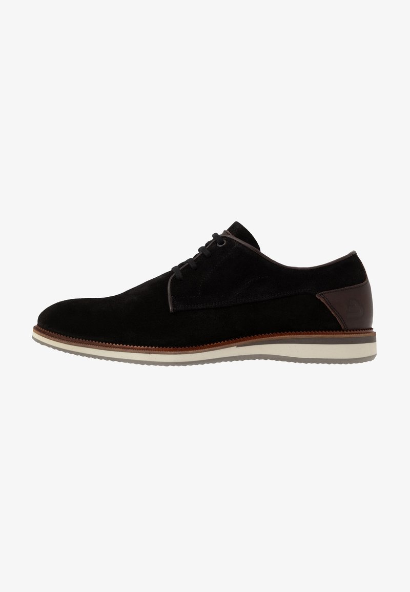 Chaussure habillée à lacets pour homme en daim noir avec languette de talon en cuir marron et semelle blanche en caoutchouc, vue de profil côté droit.