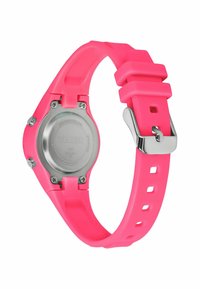 Montre Timex avec un bracelet en silicone rose, un dos en acier inoxydable et des détails en argent. Le design présente des trous carrés et une texture lisse.