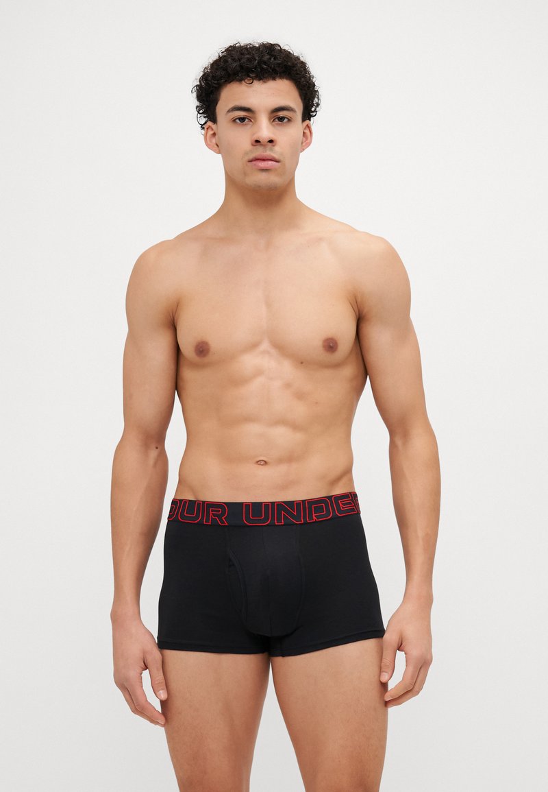 Schwarze Herrenboxershorts aus Baumwolle mit einem roten, gebrandeten Bund. Merkmale ein enganliegendes Design und eine glatte Textur.