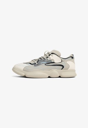 Beige sneaker with textured upper and soft rubber sole. Features blue accents and a wave pattern. Laced design with padded collar.