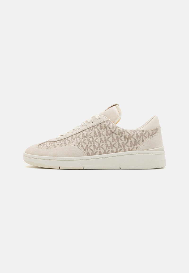 Beige színű, alacsony szárú sneaker, fehér talppal, fűzős elejével, velúr orrával és a szövet oldalsó panelején ismétlődő "MK" logó mintával.