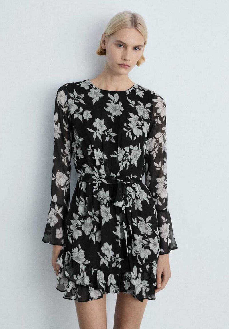 Black floral dress in lightweight fabric, featuring long sleeves, a cinched waist with a tie, and a ruffled hemline with a white flower pattern.