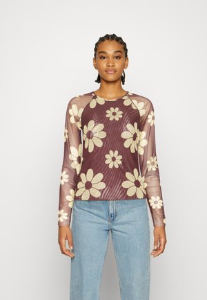 Top de malha de mangas compridas com uma base em cor cereja e grandes padrões florais em creme. Decote arredondado, mangas raglan e uma textura ligeiramente brilhante.