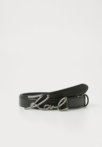 Zwarte leren riem met een glanzende zilveren metalen gesp in de vorm van de naam "Karl." Zachte textuur met een minimalistisch ontwerp.