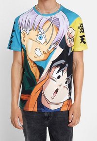 Camiseta de manga corta con un gráfico colorido de personajes de dibujos animados, predominantemente en azul, negro y naranja, con contornos marcados y detalles vibrantes.
