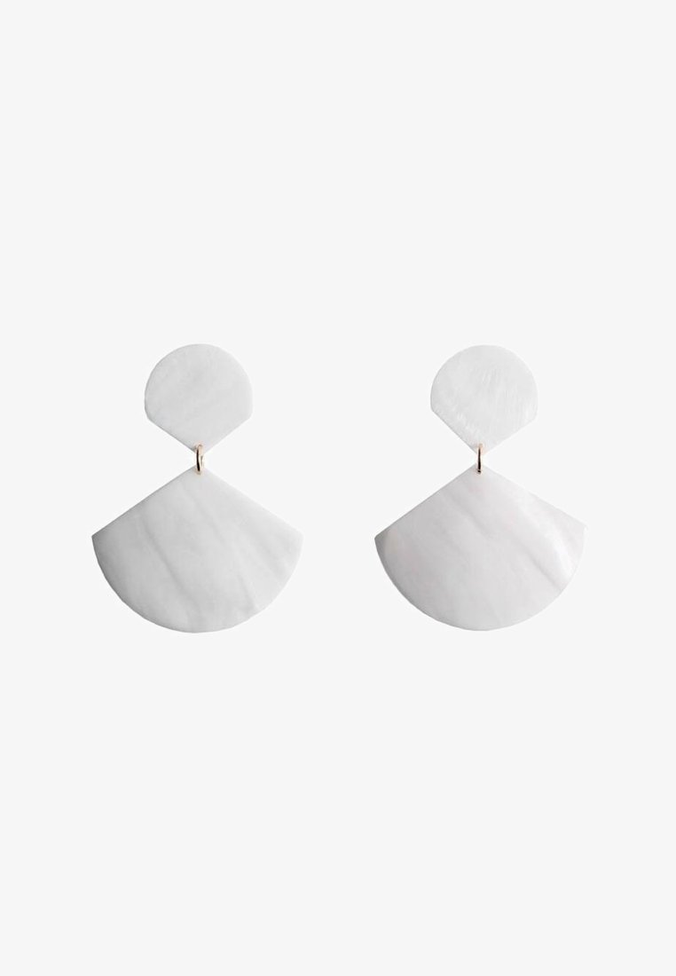 Boucles d'oreilles blanches avec un sommet circulaire et un bas en forme d'éventail, fabriquées à partir d'un matériau lisse avec une finition brillante et des accents en matériel doré.