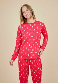 Conjunto de pijama rojo que incluye una blusa de manga larga y pantalones, decorado con coloridos estampados temáticos de vacaciones, incluyendo gafas y estrellas, en tejido suave.
