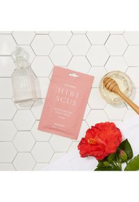 Pink packaging for Hibiscus Moisturizing Scalp Pack, a glass bottle, honey in a dish, and a red hibiscus flower on a white towel. Hexagonal tile background.