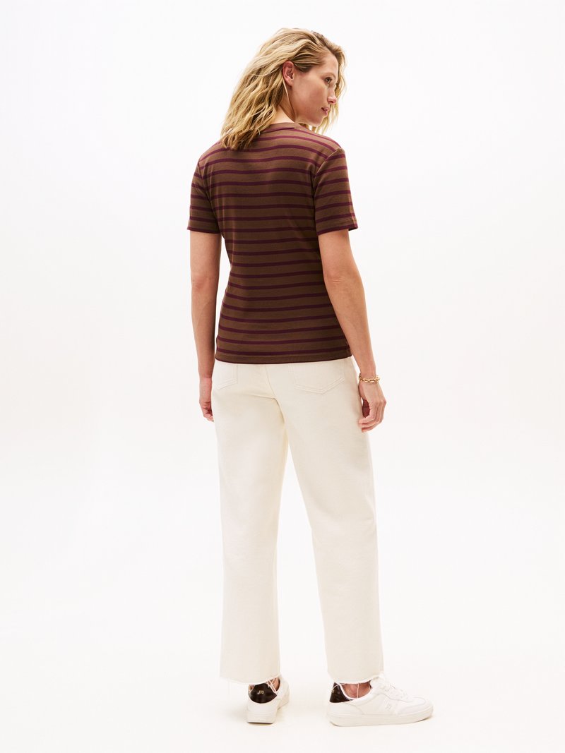 Chemise à manches courtes rayée marron, associée à un pantalon cropped crème et des baskets blanches avec des accents noirs, vue de dos.