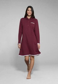 Camicetta burdeos con maniche lunghe, colletto e dettagli bianchi. Motivo a pois, lunghezza al ginocchio, realizzata in tessuto morbido, con una piccola tasca.