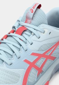 Αθλητικό παπούτσι σε ανοιχτό μπλε χρώμα με διχτυωτό επάνω μέρος και κοραλλί λεπτομέρειες. Διαθέτει υφή σχεδίασης, στρογγυλή μύτη και ενισχυμένη φτέρνα με λογότυπο.