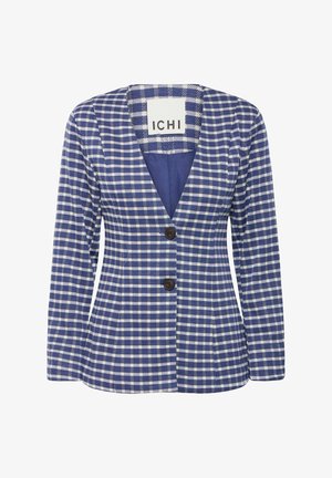 Zils un balts šūnveida žakets ar V-veida kakla izgriezumu, garām piedurknēm un divām brūnām pogām. Tam ir pieguļoša forma un mīksta tekstūra.