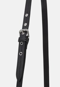 Črna usnjena zapestnica z teksturiranim zaključkom, opremljena s srebrnim okovjem in večimi luknjami za prilagajanje dolžine.