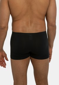 Boxer briefs neri con vestibilità aderente, vita elastica e texture liscia, caratterizzati da cuciture minime e un design posteriore senza cuciture.