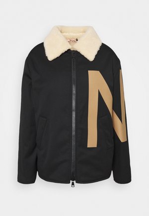 Chaqueta negra con cuello de borrego beige, cremallera frontal y un gran gráfico de la letra "N" en beige que cubre parcialmente el frente y la manga.
