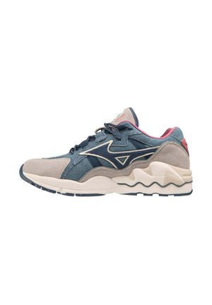 Sneaker da uomo in denim blu con dettagli in suede grigio, dotate di una suola intermedia bianca ondulata e un tallone rosa, progettate per comfort e stile.