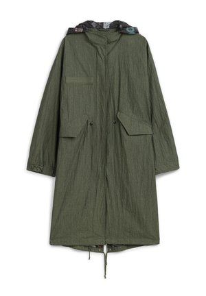Długa oliwkowozielona parka z kapturem, kieszeniami z klapami z przodu, regulowanymi sznurkami w pasie oraz wzorzystą podszewką widoczną w kapturze.