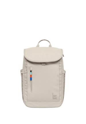 Sac à dos beige clair avec poignée supérieure, poche avant zippée avec tirette multicolore, sangles latérales et logo "GOT BAG" en bas à droite.