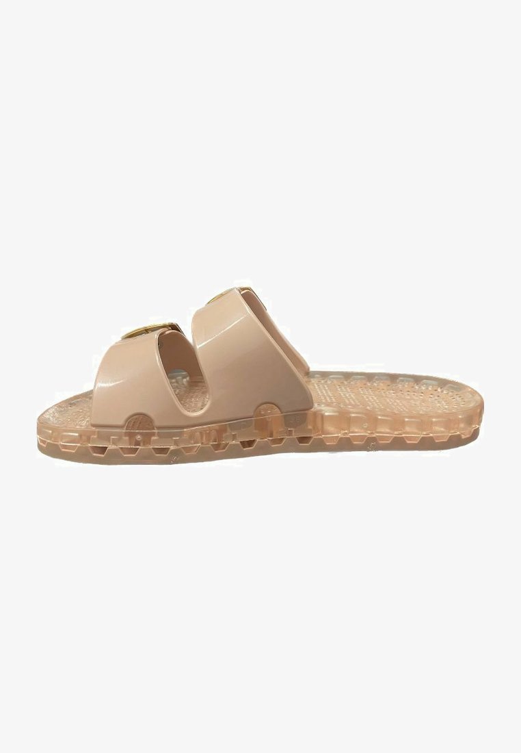Sandales en plastique rose pâle avec deux larges brides et des découpes, présentant une semelle extérieure transparente texturée avec des motifs antidérapants.