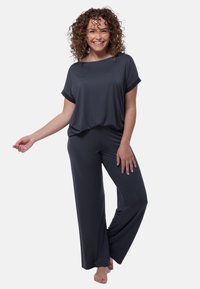 Losse, donkergrijze top met korte mouwen, gecombineerd met bijpassende wijde broek van zachte stof, wat een comfortabele loungewear-set creëert.