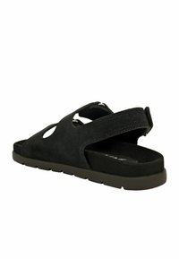 Sandalo in suede nero con design a taglio, cintura regolabile e soletta testurizzata. Suola in gomma leggera con un minimalissimo motivo di battistrada.