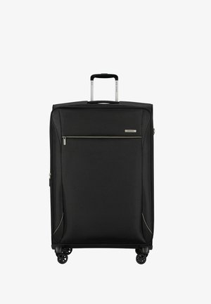 Grande valise souple noire avec poignée télescopique, poche avant zippée et quatre roues pivotantes sur fond blanc.
