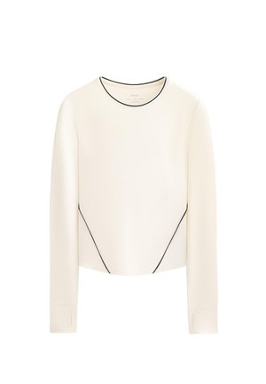 Haut crème à manches longues avec passepoils noirs, doté d'un col rond et d'un design sans coutures ; confectionné dans un tissu lisse légèrement brillant.