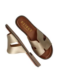 Goudkleurige instapsandalen met een uitsnijdingen ontwerp, bovenwerk van fauxleer, een bruine binnenzool en een zwart geribbelde rand met studs op de buitenzool.