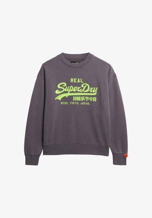 Szara bluza z okrągłym dekoltem, z wyraźnym, limonkowym nadrukiem "SUPERDRY" oraz pomarańczową metką u dołu. Miękka faktura materiału.