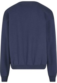 Sudadera azul marino con cuello redondo, mangas largas y puños acanalados. Textura suave con un dobladillo fruncido en la cintura. Sin patrones ni acentos.