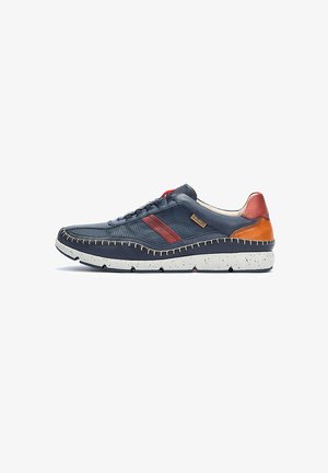 Scarpa sportiva in pelle blu navy con dettagli rossi e arancioni, superficie texturizzata, suola grigia con macchie, e cuciture a contrasto.
