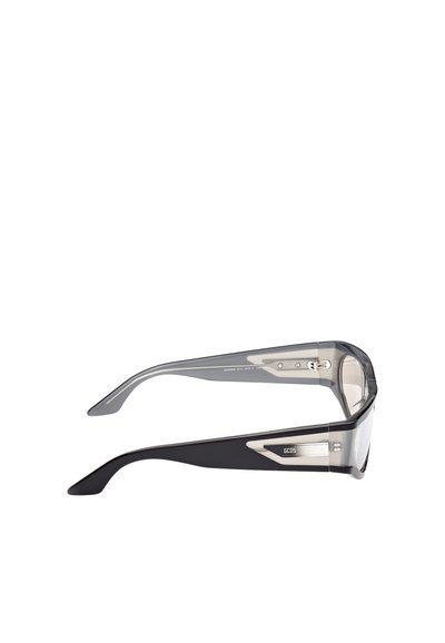 Lunettes de soleil avec des verres gris transparents et des branches noires brillantes, dotées d'accents argentés métalliques et d'un design épuré.