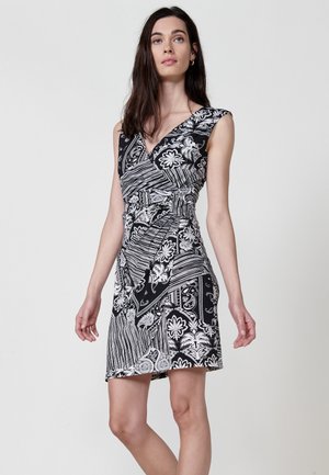 Schwarz-weiß gemustertes Kleid mit tailliertem Schnitt, V-Ausschnitt und kurzen Ärmeln; es weist florale und gestreifte Designs auf.