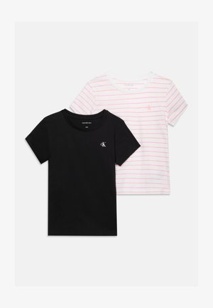 Dve kratkotrajni majici s kratkimi rokavi znamke Calvin Klein, ena črna z belim logotipom, druga bela z tankimi rdečimi črtami in rdečim logotipom, položeni na ravno belo ozadje.