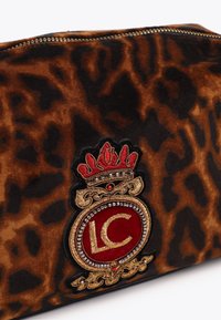 Pouch od baršuna s uzorkom leoparda s izvezenim logom krune, s istaknutim crvenim i zlatnim okruglim grbom i zlatnim detaljima na zatvaraču.