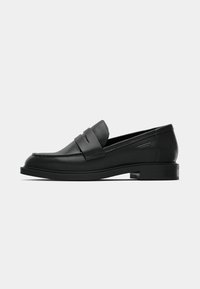 Black leather loafer with a rounded toe, decorative strap across the vamp, and a low block heel. Smooth texture and streamlined design.