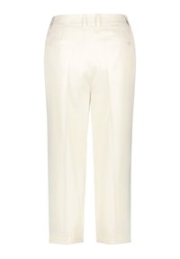 Crèmekleurige broeken met een gladde textuur, voorzien van twee achterzakken, een taps toelopende pasvorm en subtiele plooien. Tailored tailleband met riemlussen.