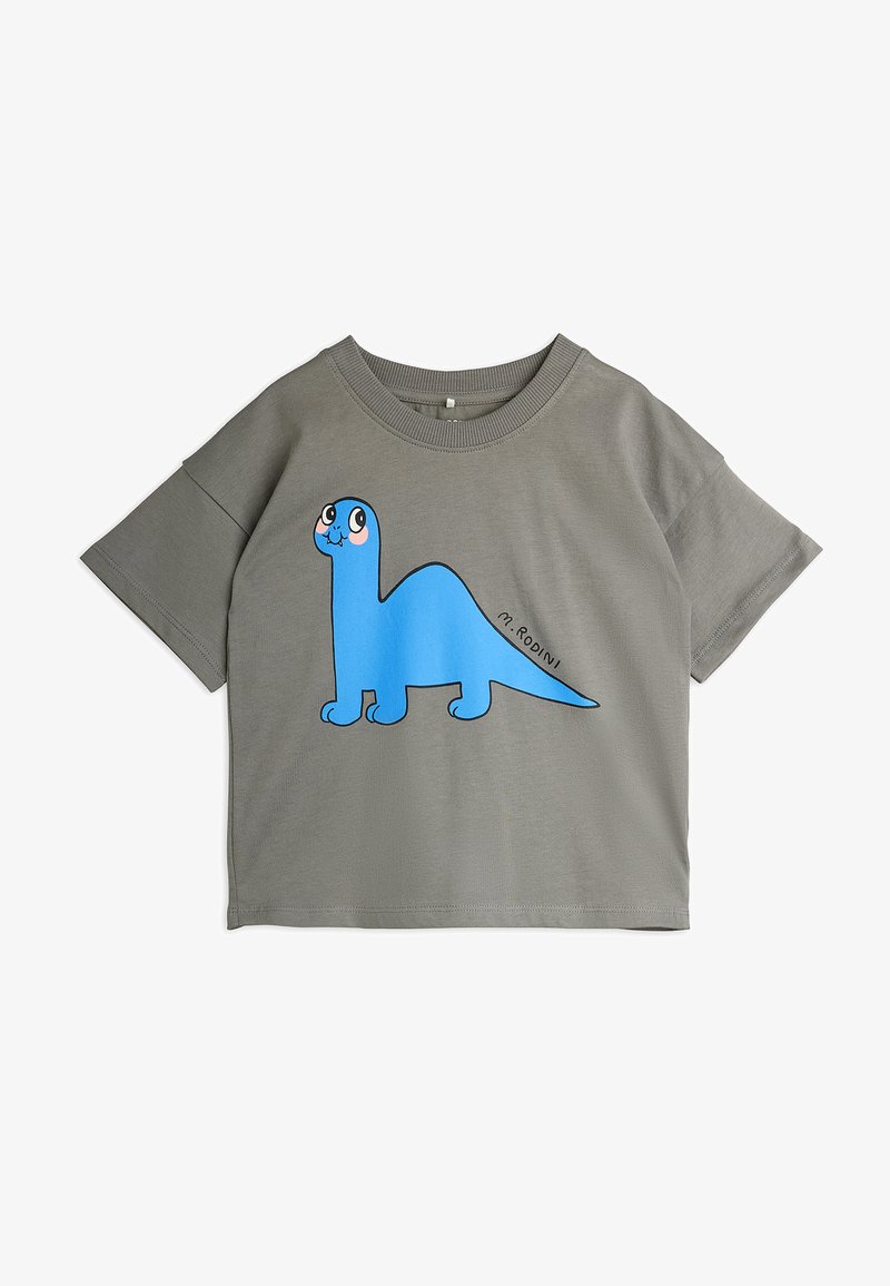 Pelēks īsām piedurknēm T-krekls ar lielu zilu karikatūras dinozaura grafiku ar izteiksmīgām acīm, izgatavots no mīkstas kokvilnas auduma.