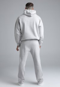 Grijze set van sweatshirt en joggingbroek gemaakt van zachte fleece. Voorzien van een capuchon, losse pasvorm en geribbelde boorden. Getextureerd oppervlak met een gladde afwerking.