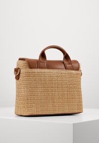 Borsa in paglia intrecciata con parte superiore e manici in pelle marrone. Forma rettangolare con dettagli in hardware dorato sui lati.