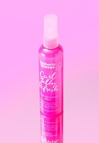 Spray Revitalisant pour Boucles d'Umberto Giannini dans un flacon translucide rose avec un vaporisateur, comportant un texte blanc et une base réfléchissante.