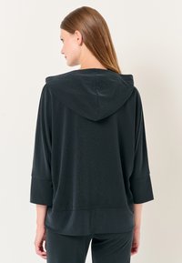 Felpa nera con cappuccio realizzata in tessuto morbido, caratterizzata da una vestibilità comoda, maniche a tre quarti e un motivo testurizzato sottile.