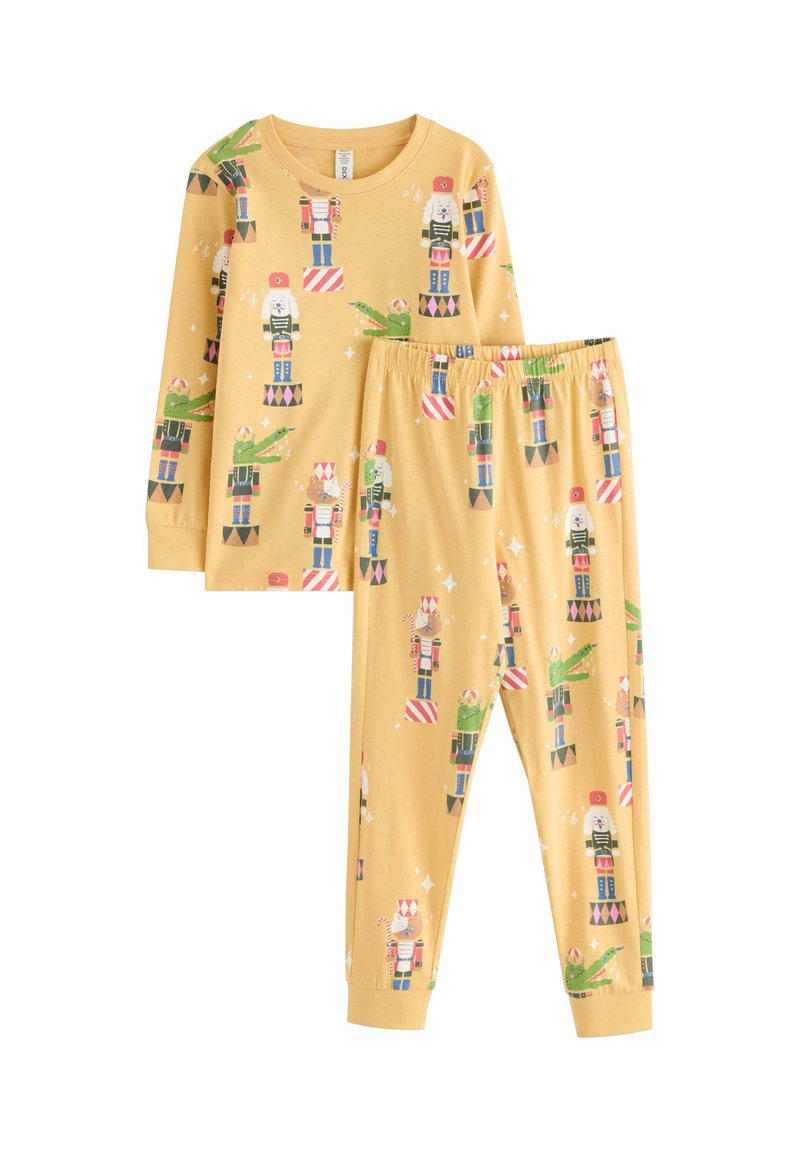 Ensemble de pyjama à manches longues jaunes avec des motifs de casse-noisette et de fête. Comprend un pantalon à taille élastique assorti. Matériau en coton doux.