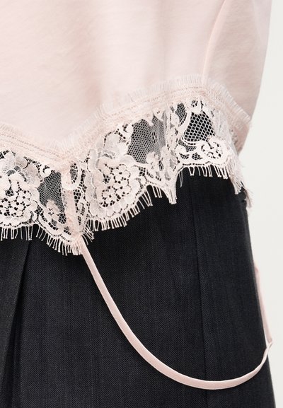 Υφασμα απαλού ροζ χρώματος με διακοσμητικό δαντελένιο τελείωμα με λουλούδια πάνω σε μαύρο υφή υφάσματος, με λεπτή ροζ σατέν κορδέλα.