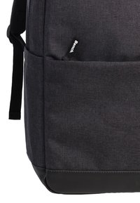 Sac à dos en tissu noir avec une finition texturée ; il dispose d'une poche avant, de bretelles réglables et d'un panneau inférieur renforcé.