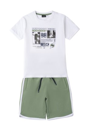 T-shirt bianco in cotone con stampa grafica e testo, abbinata a pantaloni corti verdi con cordoncino e strisce laterali bianche.